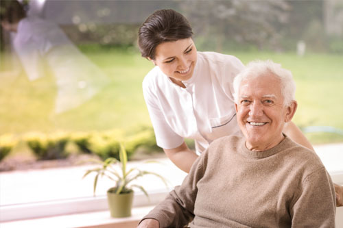 Nurse at home smiling with her elderly patient